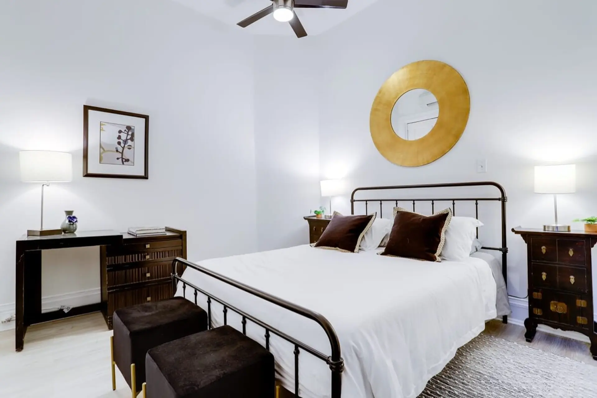 A bedroom with a bed, nightstands, and a desk.