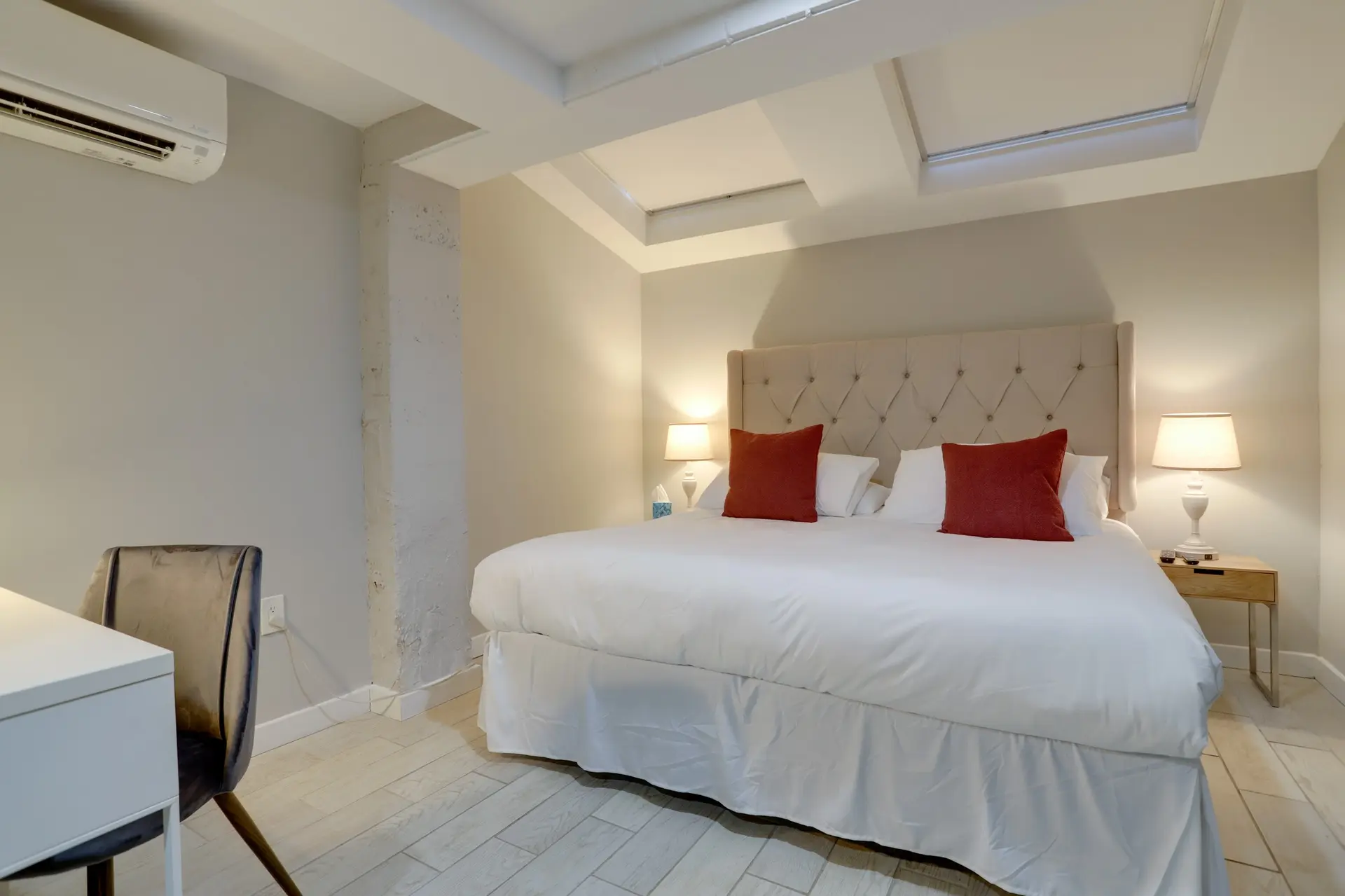 A bedroom with a bed, desk and chair.