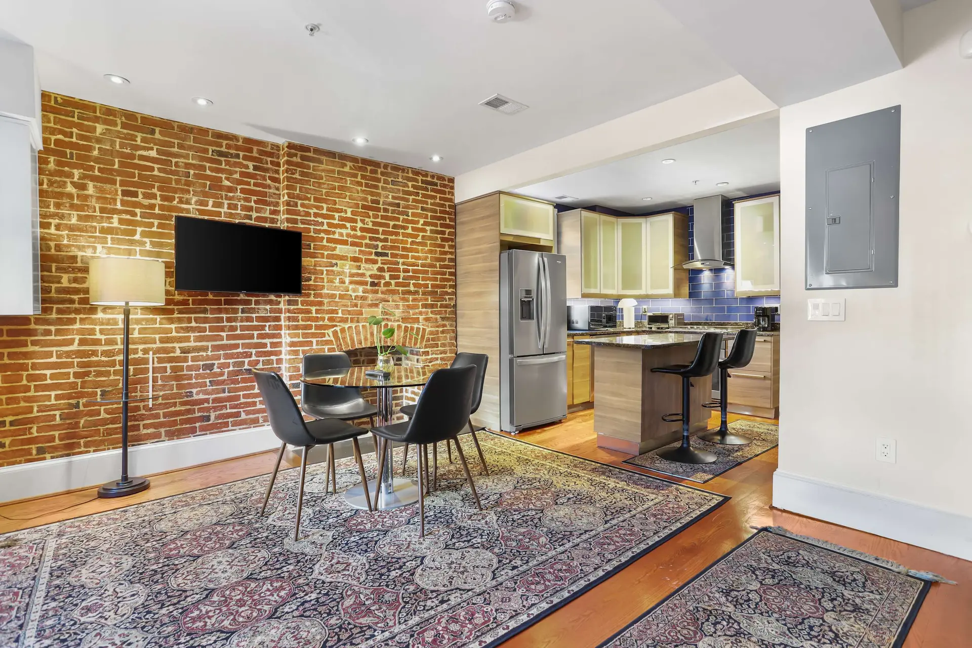 Modern apartment with exposed brick, dining area, and open kitchen.