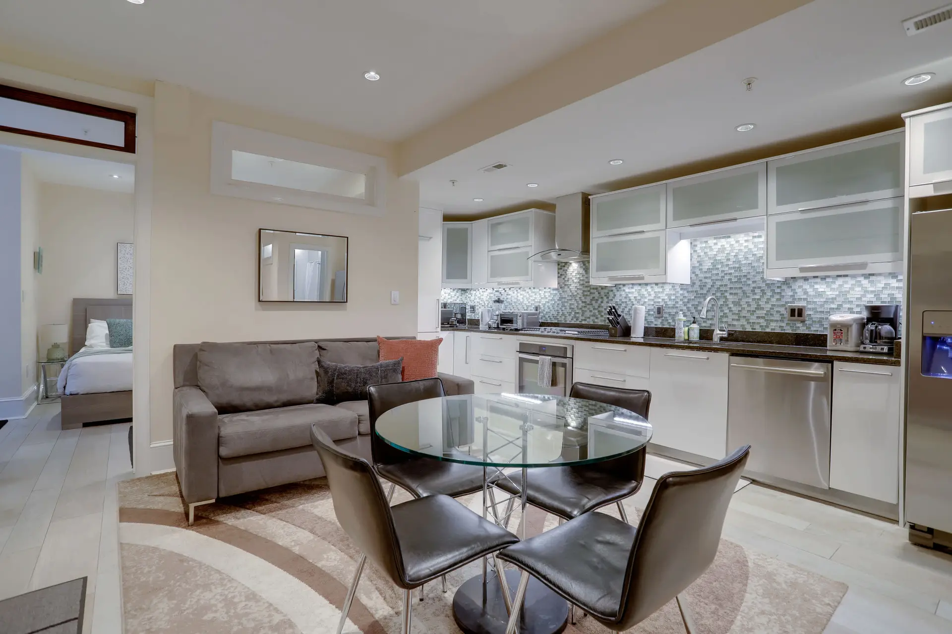 A modern studio apartment with a kitchen, living area, and bedroom.