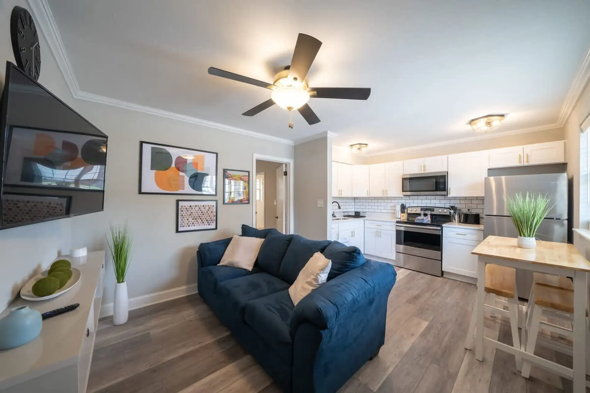A navy blue couch faces a TV mounted on the wall in this living room.