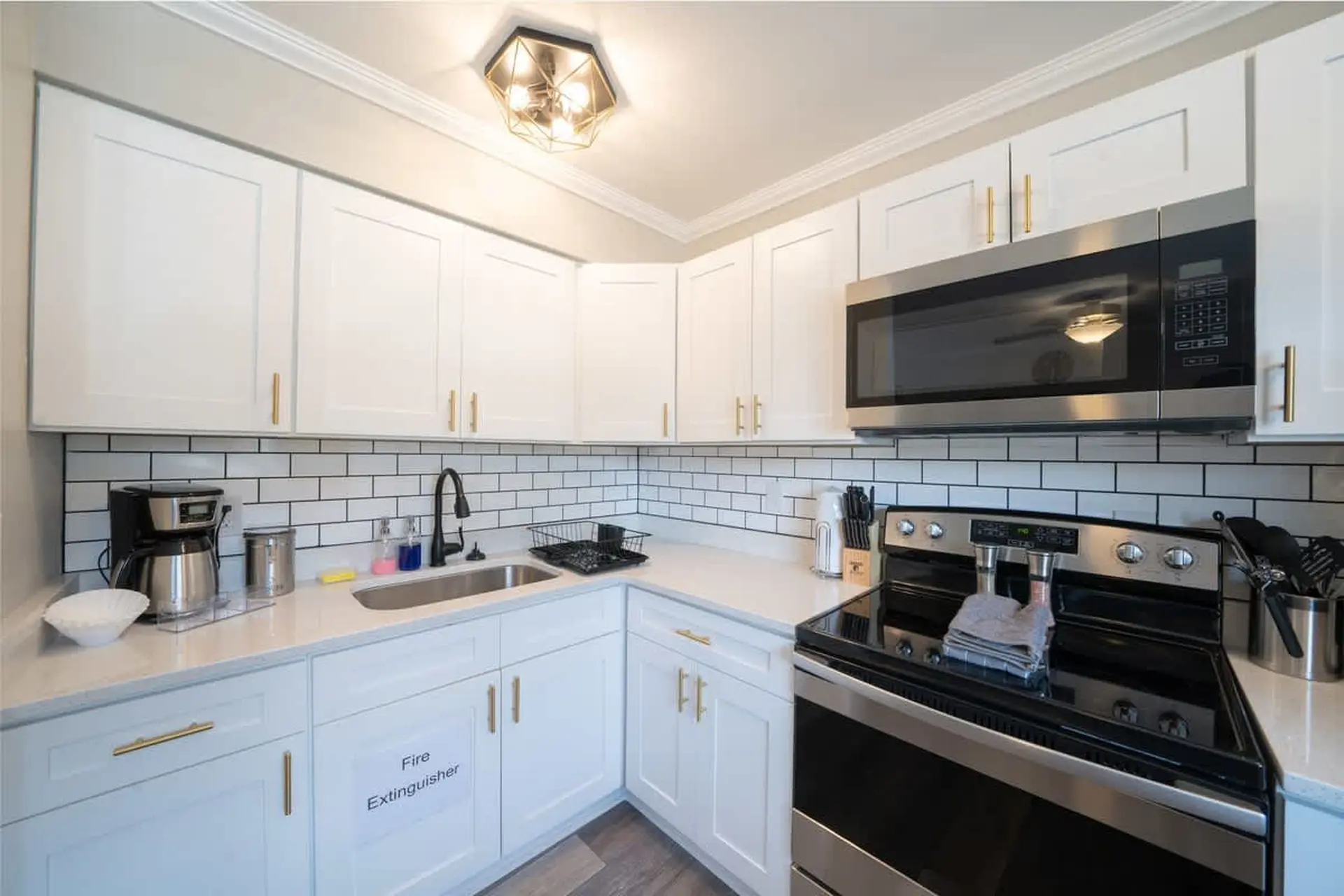A modern kitchen with white cabinets, stainless steel appliances, and a subway tile backsplash.