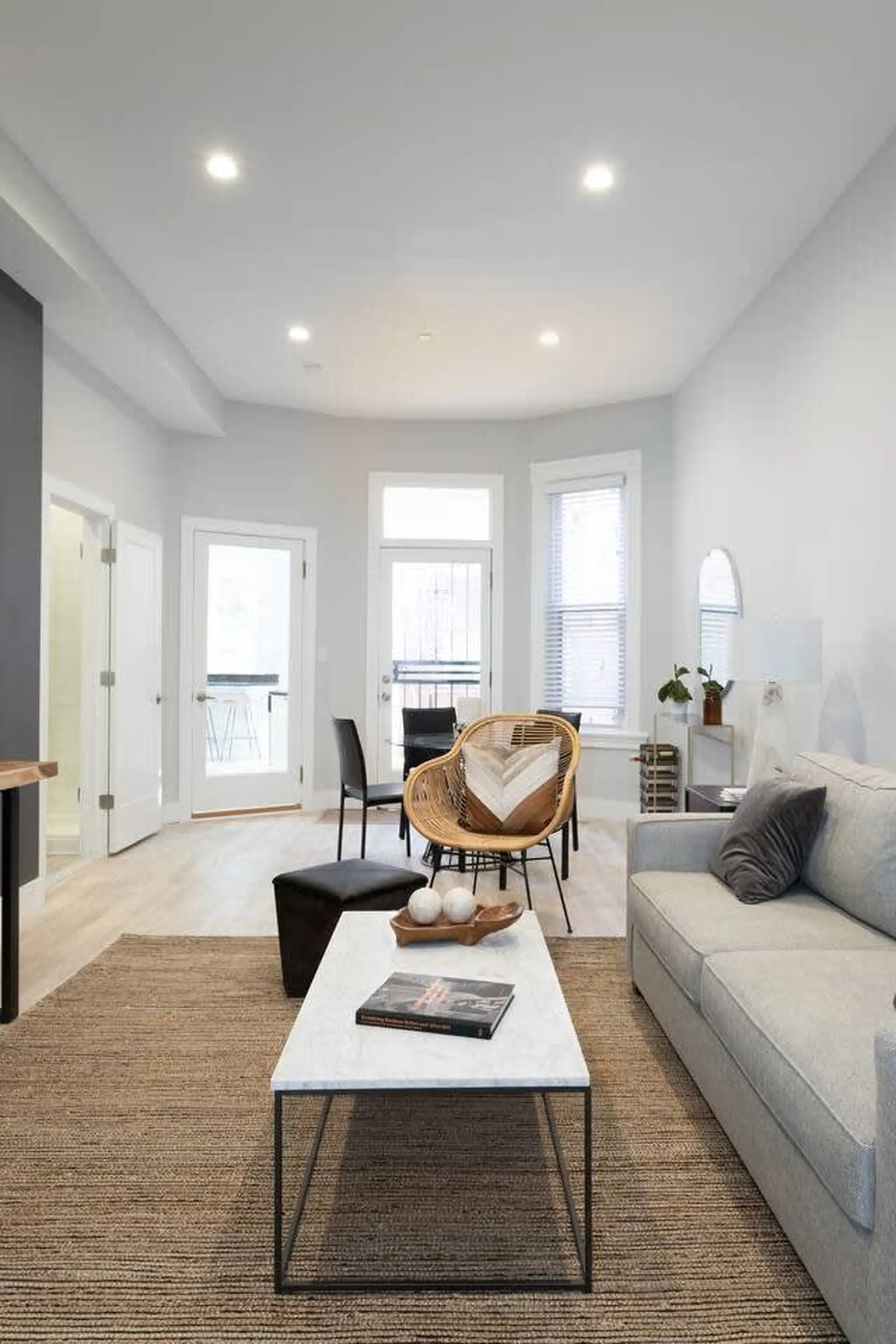 A modern living room with a sofa, coffee table, and chairs.