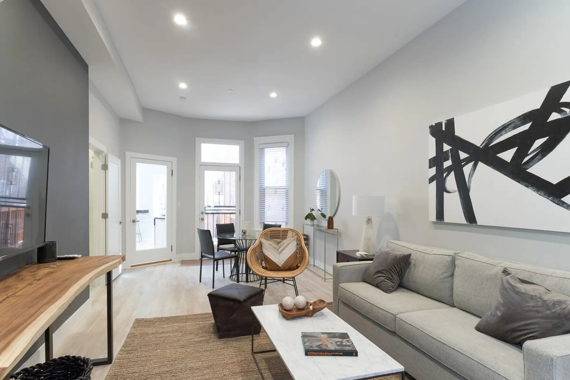 A contemporary living room with a sofa, coffee table, and a large abstract painting on the wall.