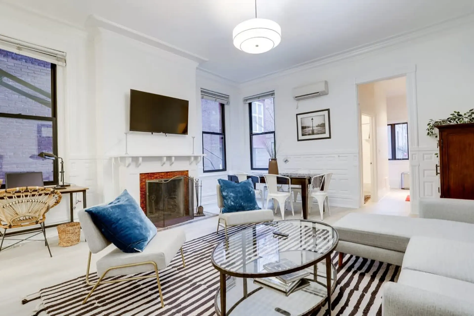 A living room with a fireplace, couch, coffee table, and dining area.