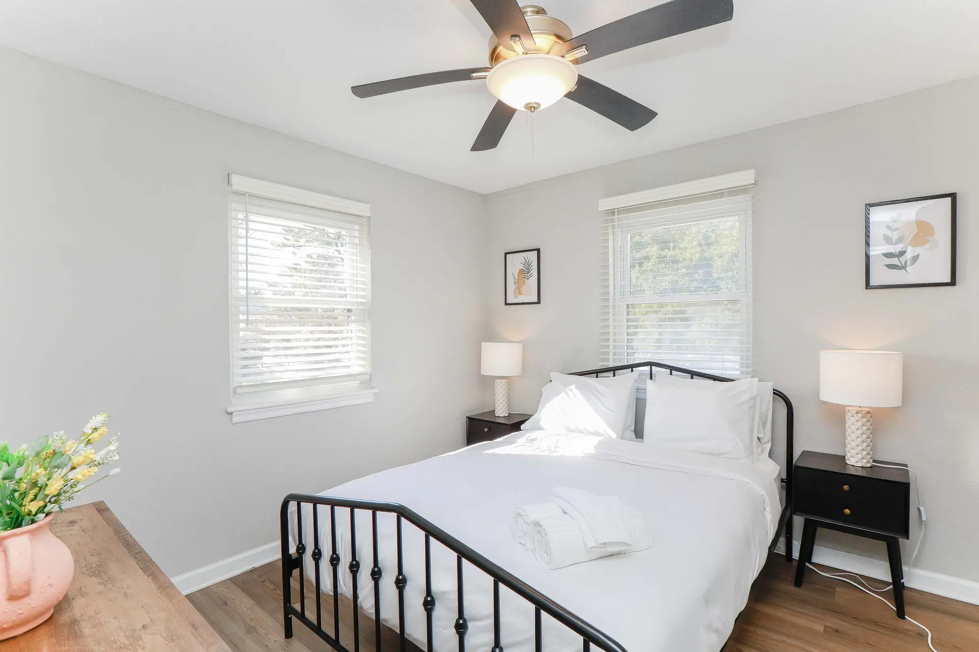Bedroom with a bed, two nightstands, and a ceiling fan.