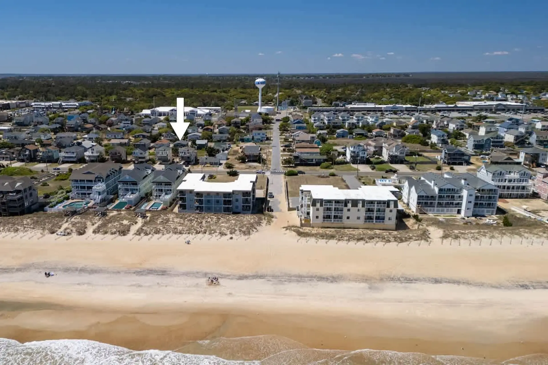 Aerial view of a coastal town with buildings, a beach, and the ocean.