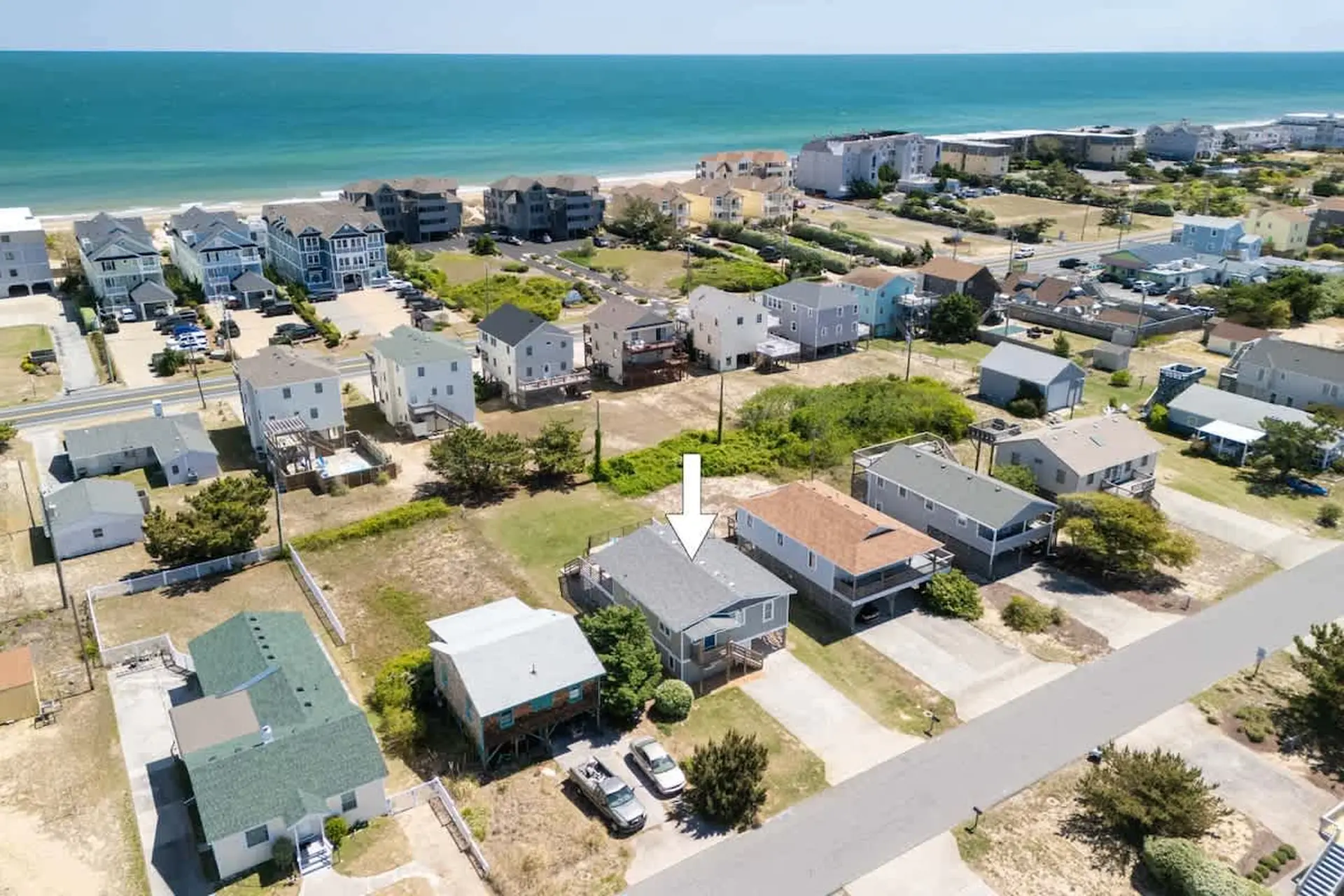 Aerial view of houses with beach and ocean in the background.