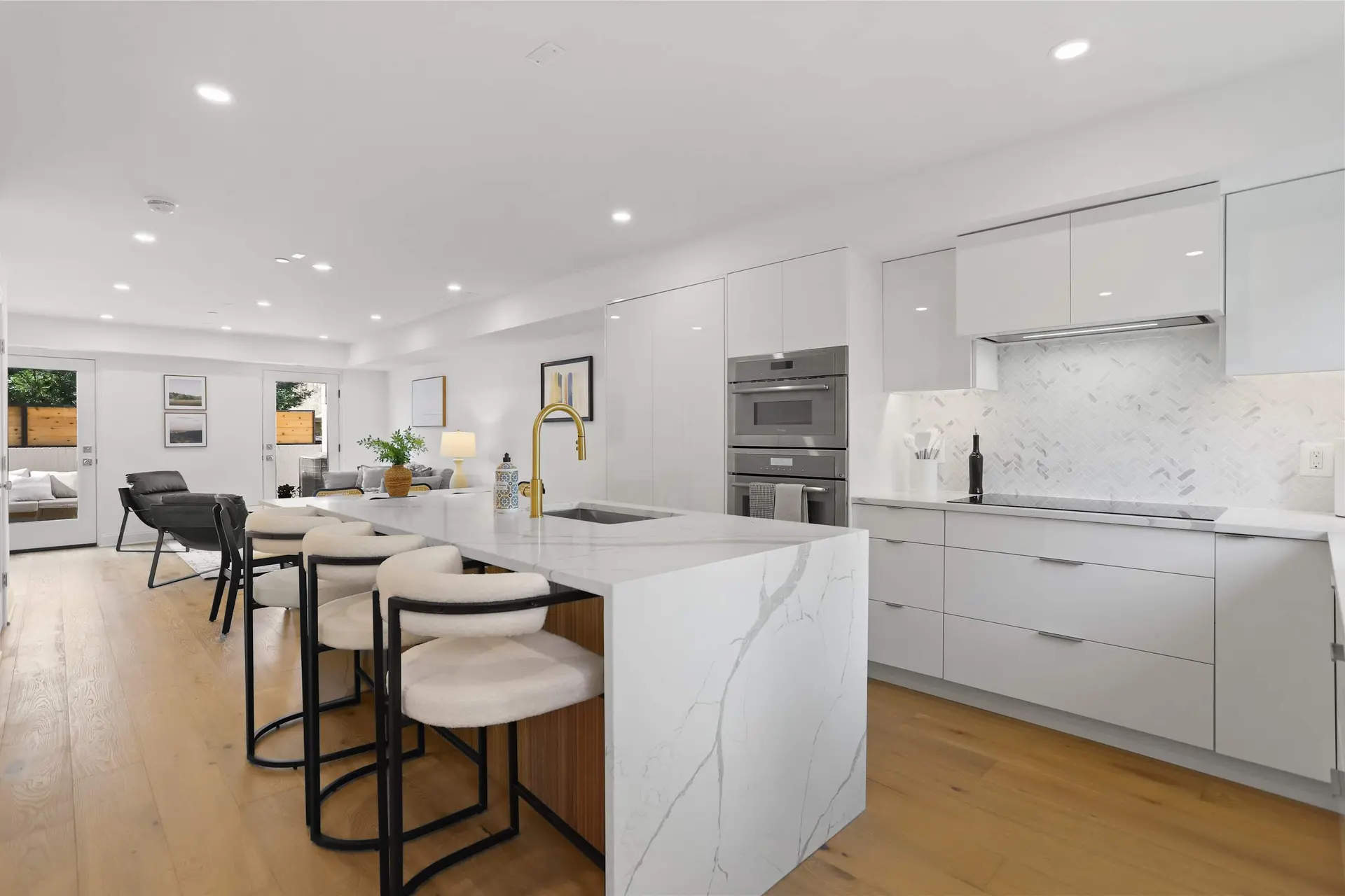 Modern kitchen with island seating and stainless steel appliances.