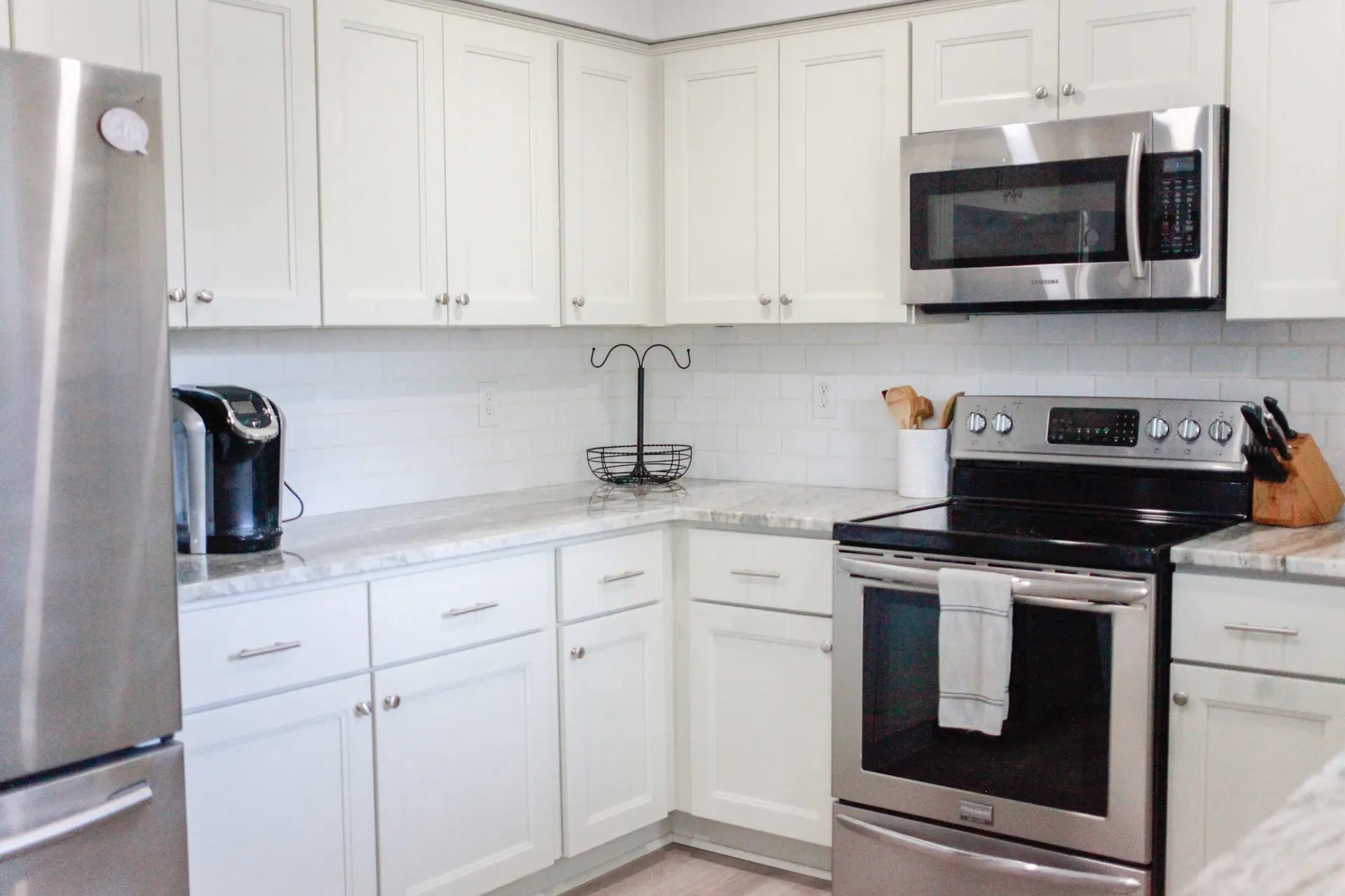 A kitchen with white cabinets and stainless steel appliances.