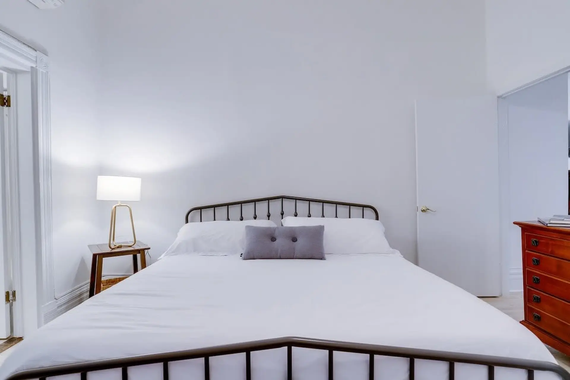 A white bed with pillows and a white sheet.