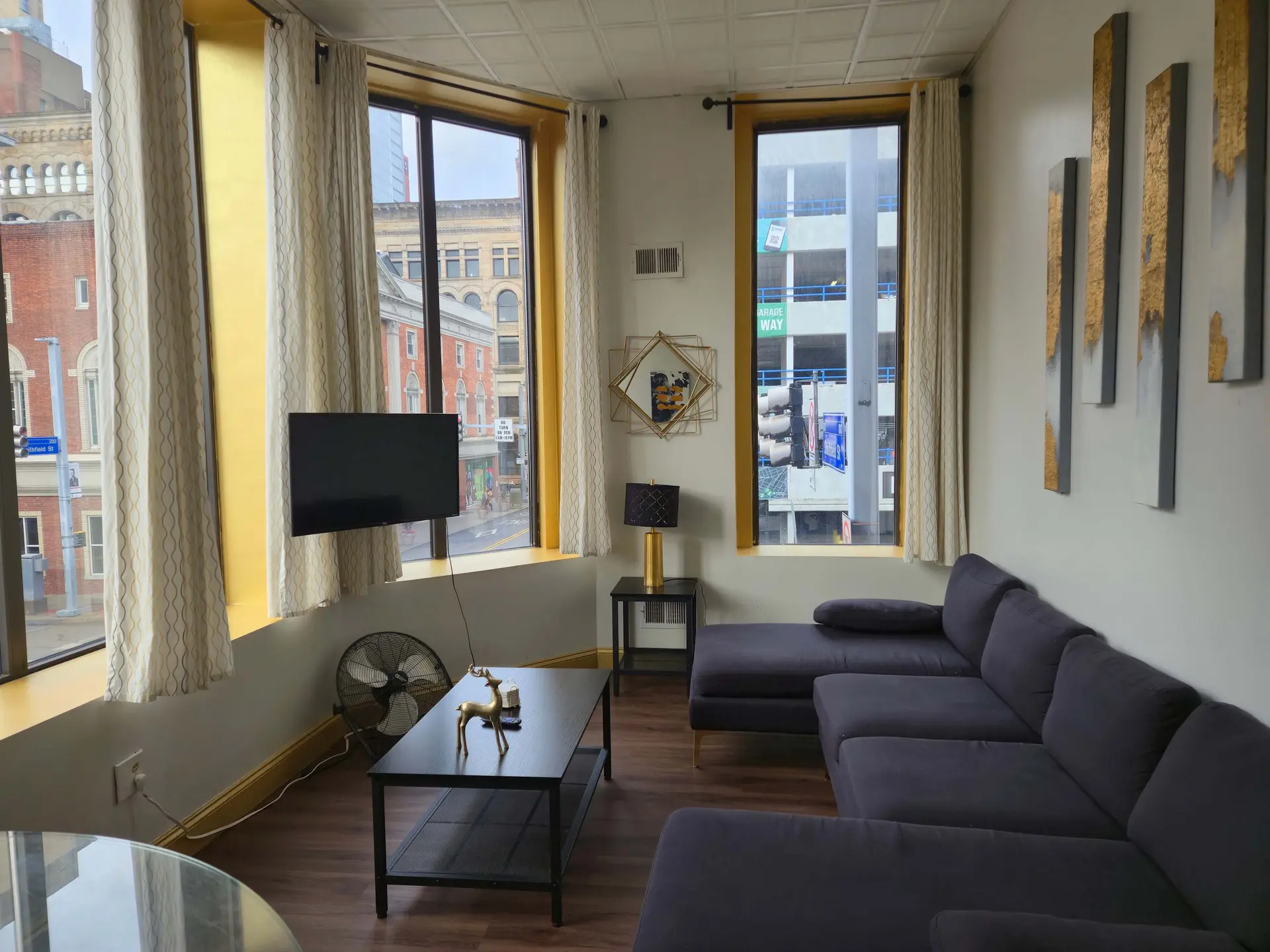 A modern living room with a dark gray sectional sofa and coffee table.