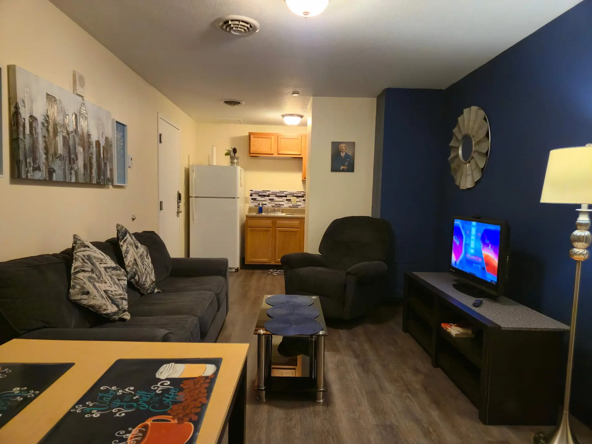 Living room with a couch, armchair, coffee table, and TV.
