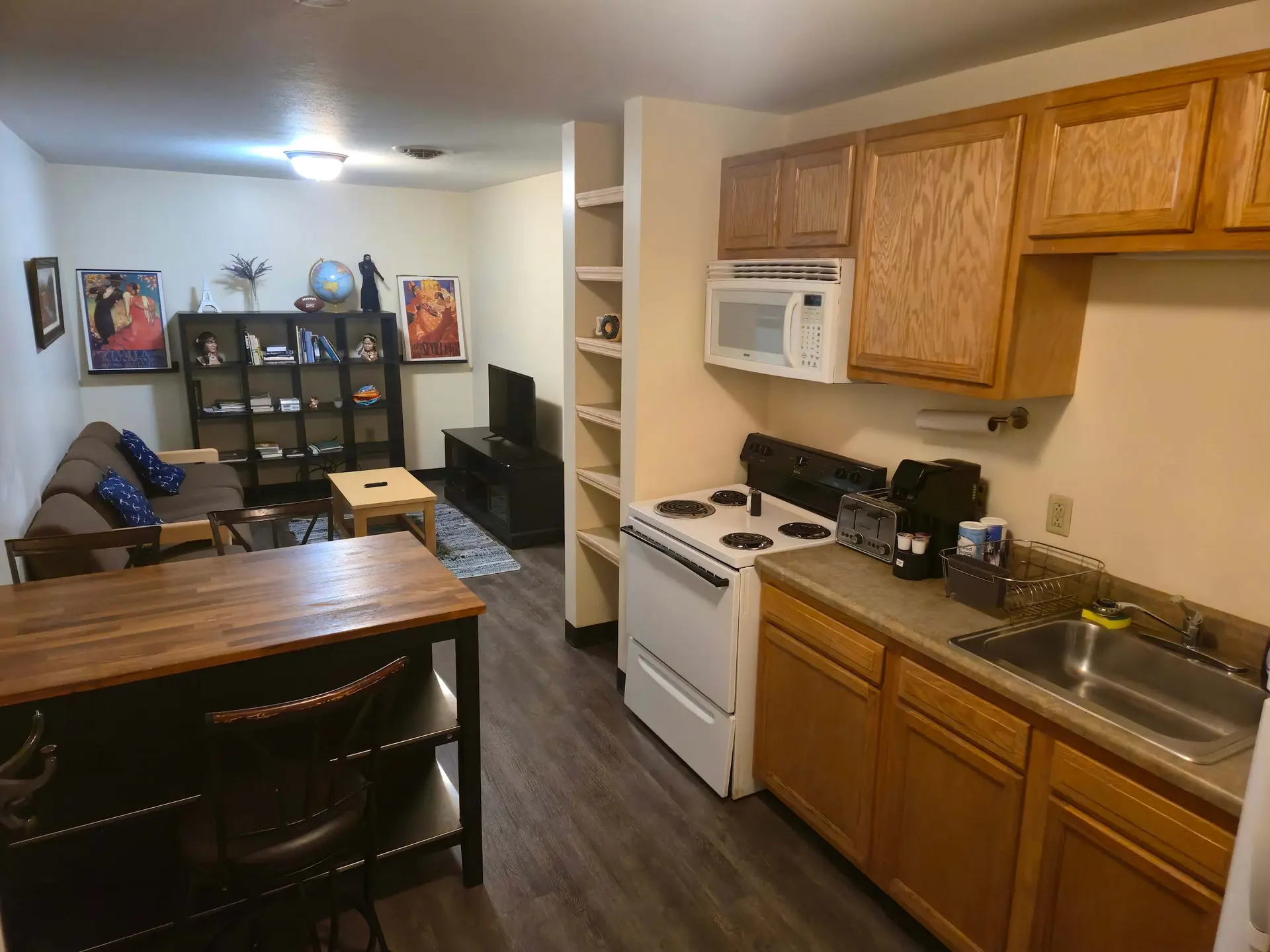 A spacious studio apartment with a kitchen, living area, and dining space.