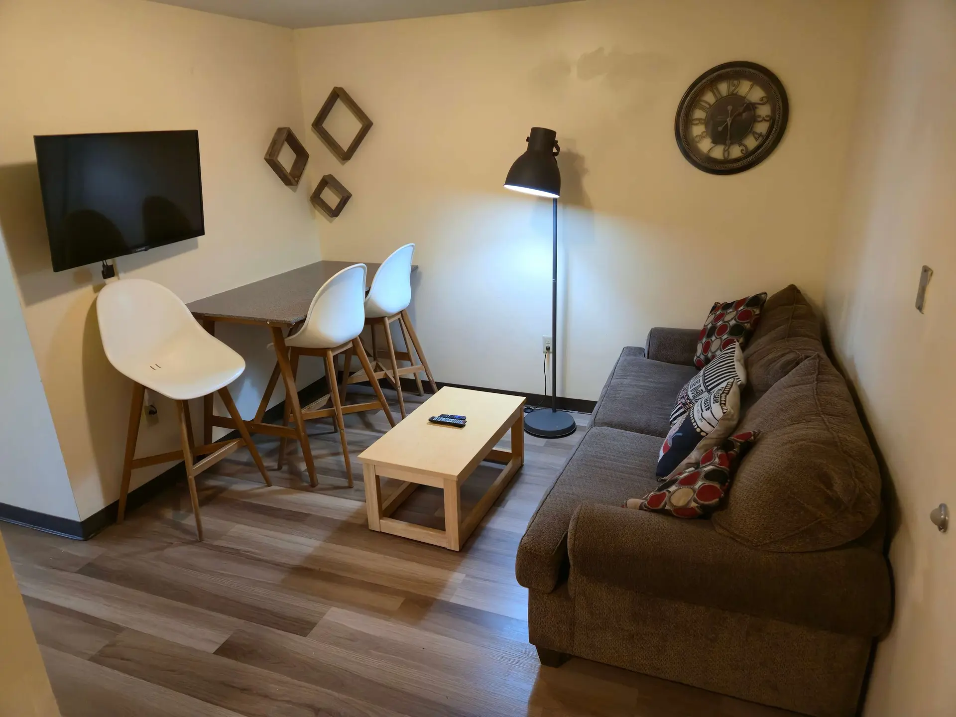 Living room with sofa, coffee table, chairs, and TV.