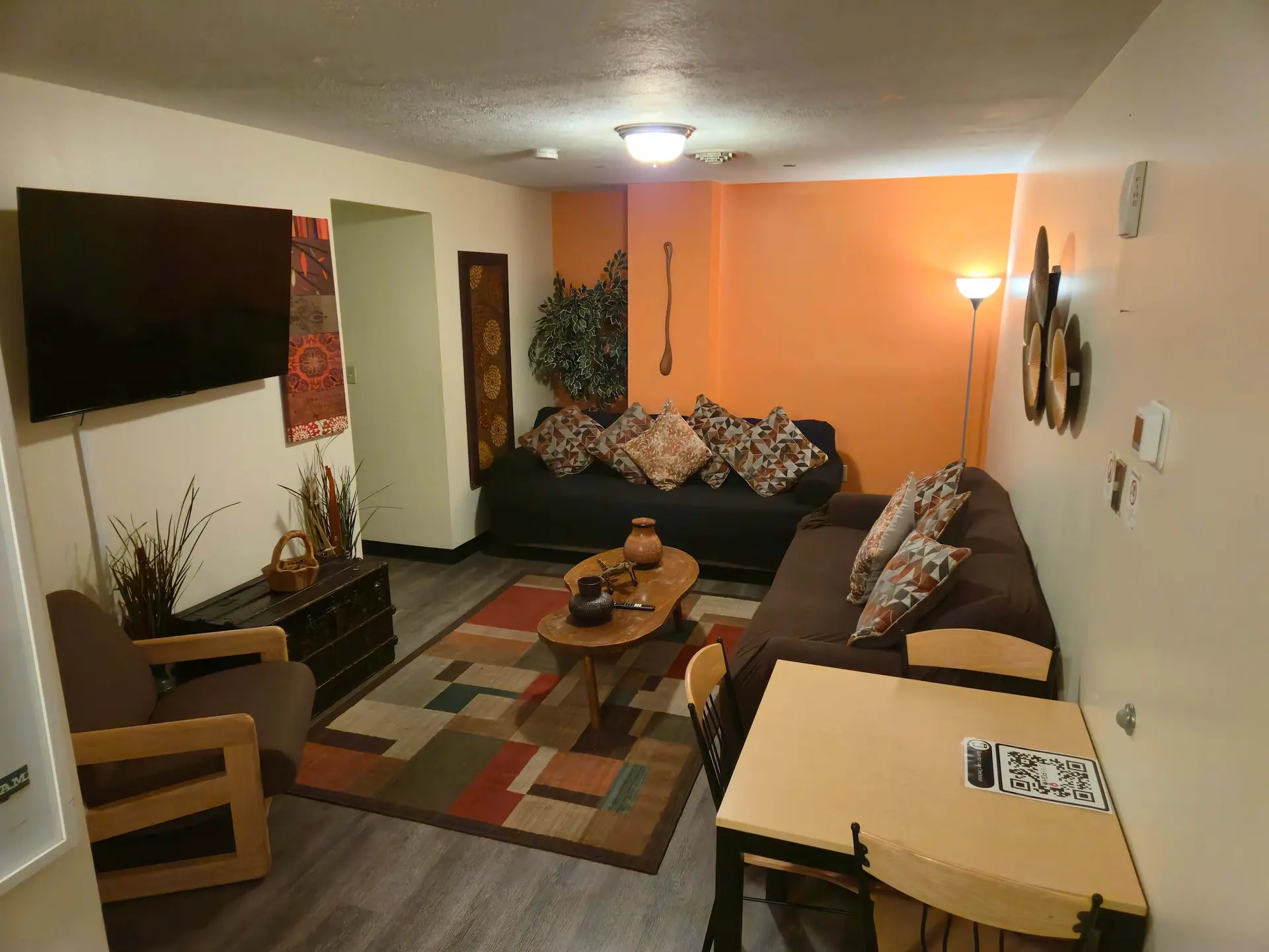 A living room with a sofa, chairs, coffee table, and a TV.