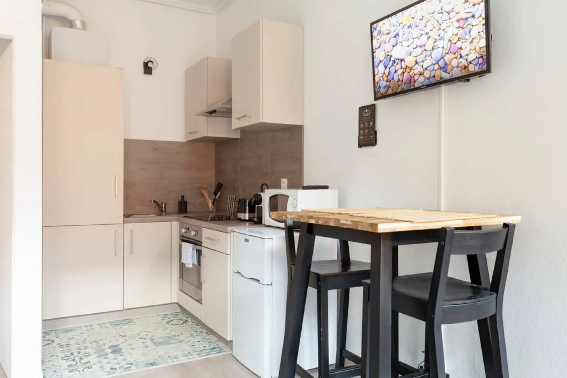 Modern kitchen with a dining table and chairs, a microwave, and a refrigerator.