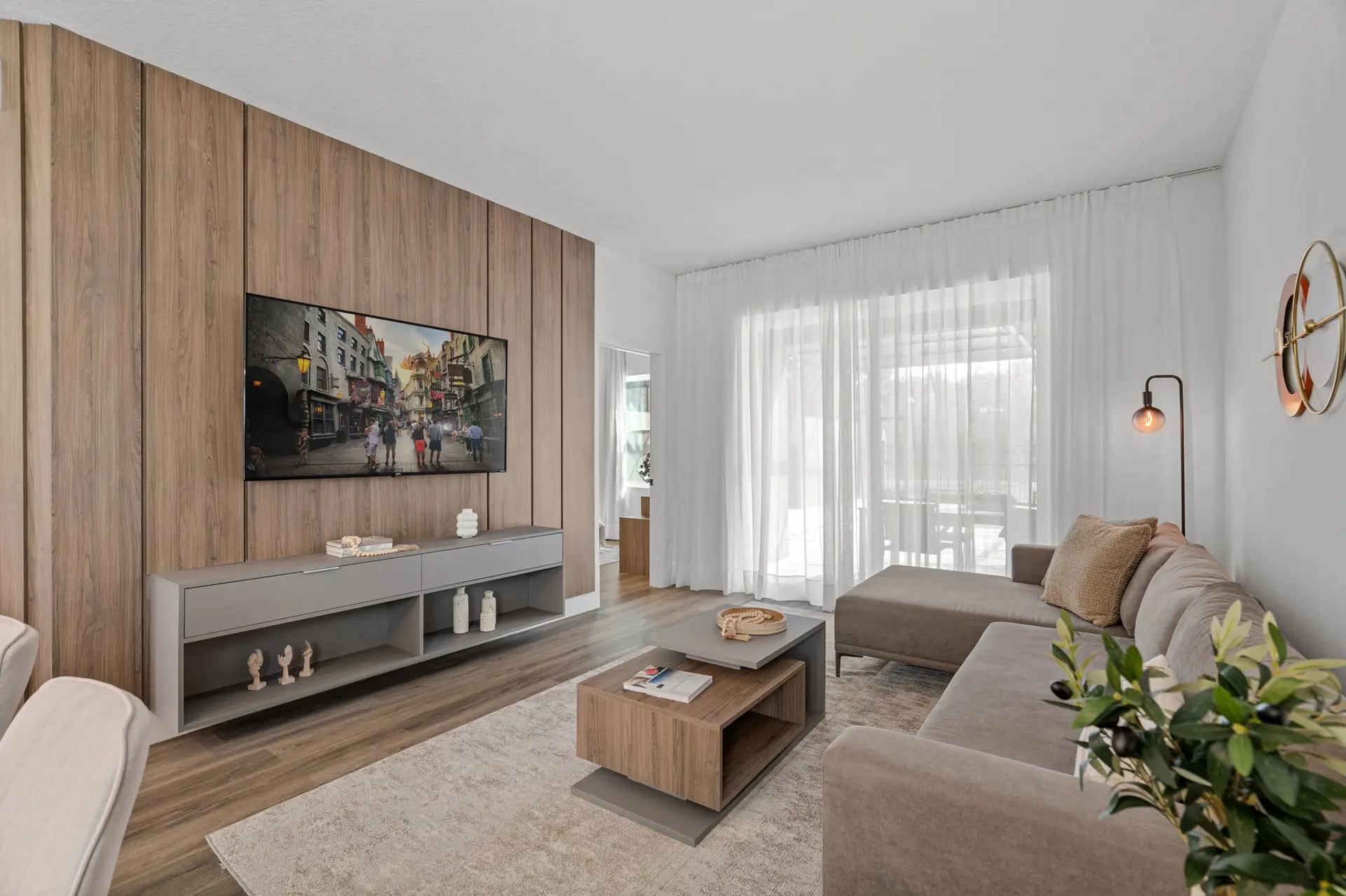 A spacious living room with a TV, sectional sofa, and coffee table.