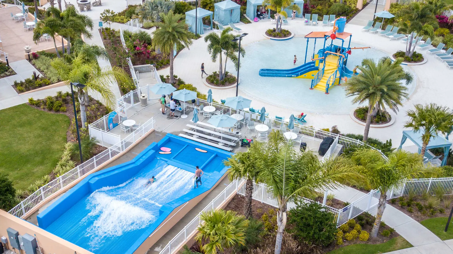 An aerial view of a water park with a wave pool, slides, and lounge chairs.