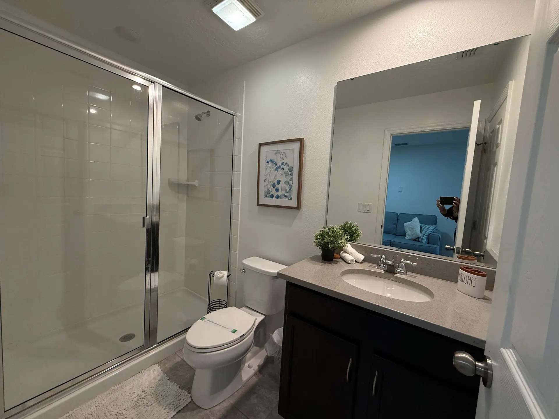 A bathroom with a shower, toilet, and vanity.