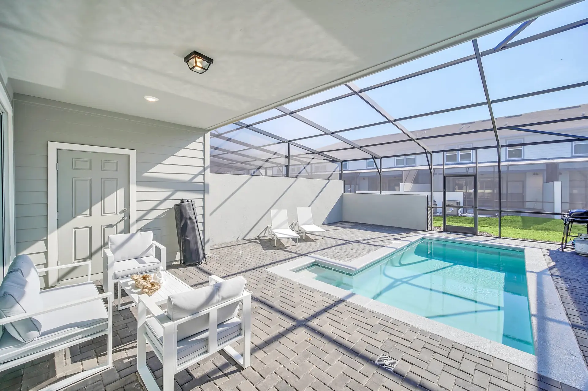 Outdoor patio with a pool, lounge chairs, and seating area.