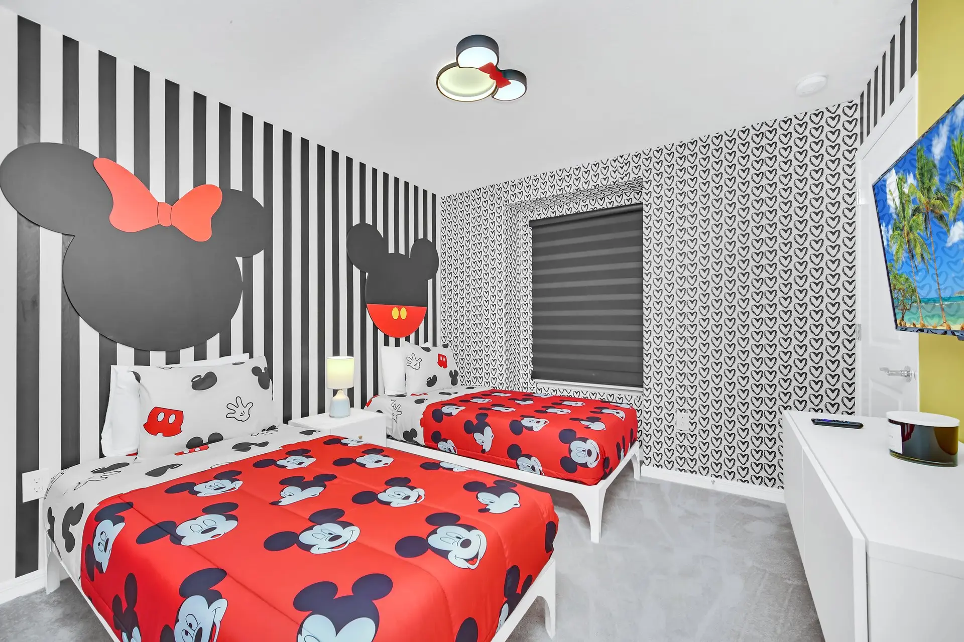 A Disney-themed bedroom with twin beds and Mickey Mouse decor.
