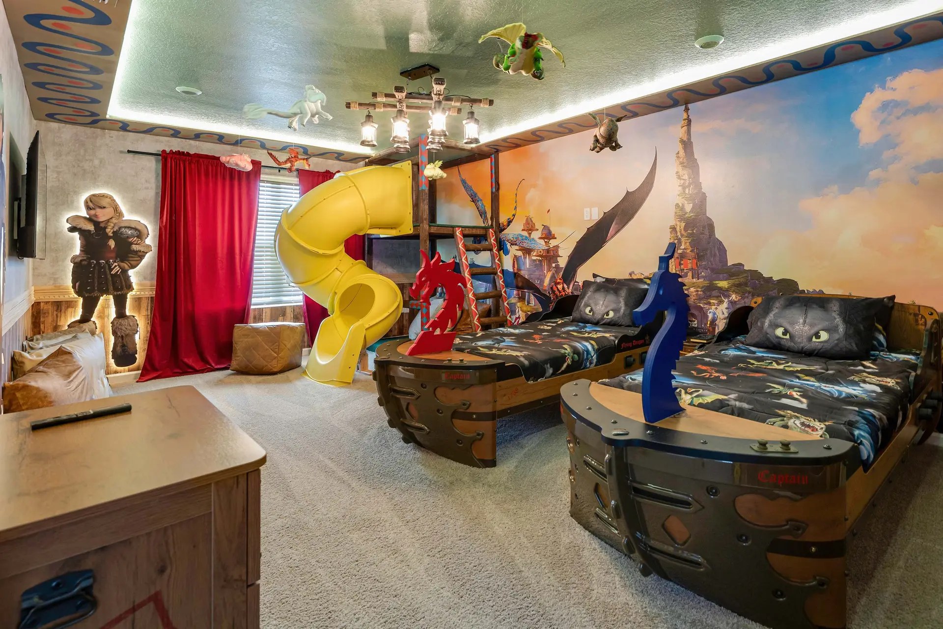 Dragon-themed bedroom with a yellow slide, bunk beds, and dragon decorations.