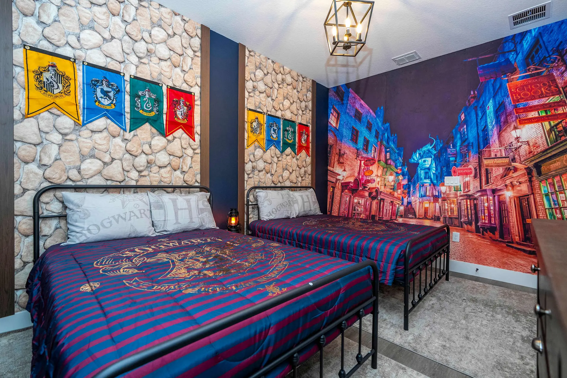 A Harry Potter-themed bedroom features two beds with Hogwarts-themed bedding and a wall mural of Dia