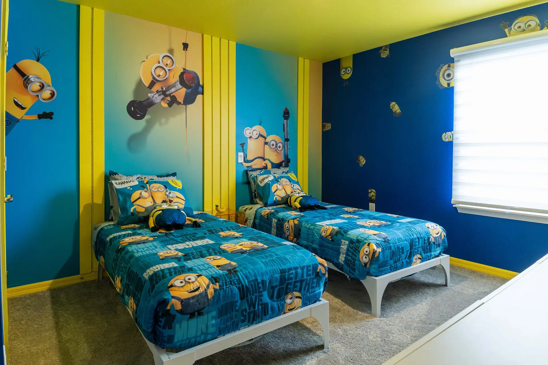 A bedroom featuring two twin beds with Minion-themed bedding.