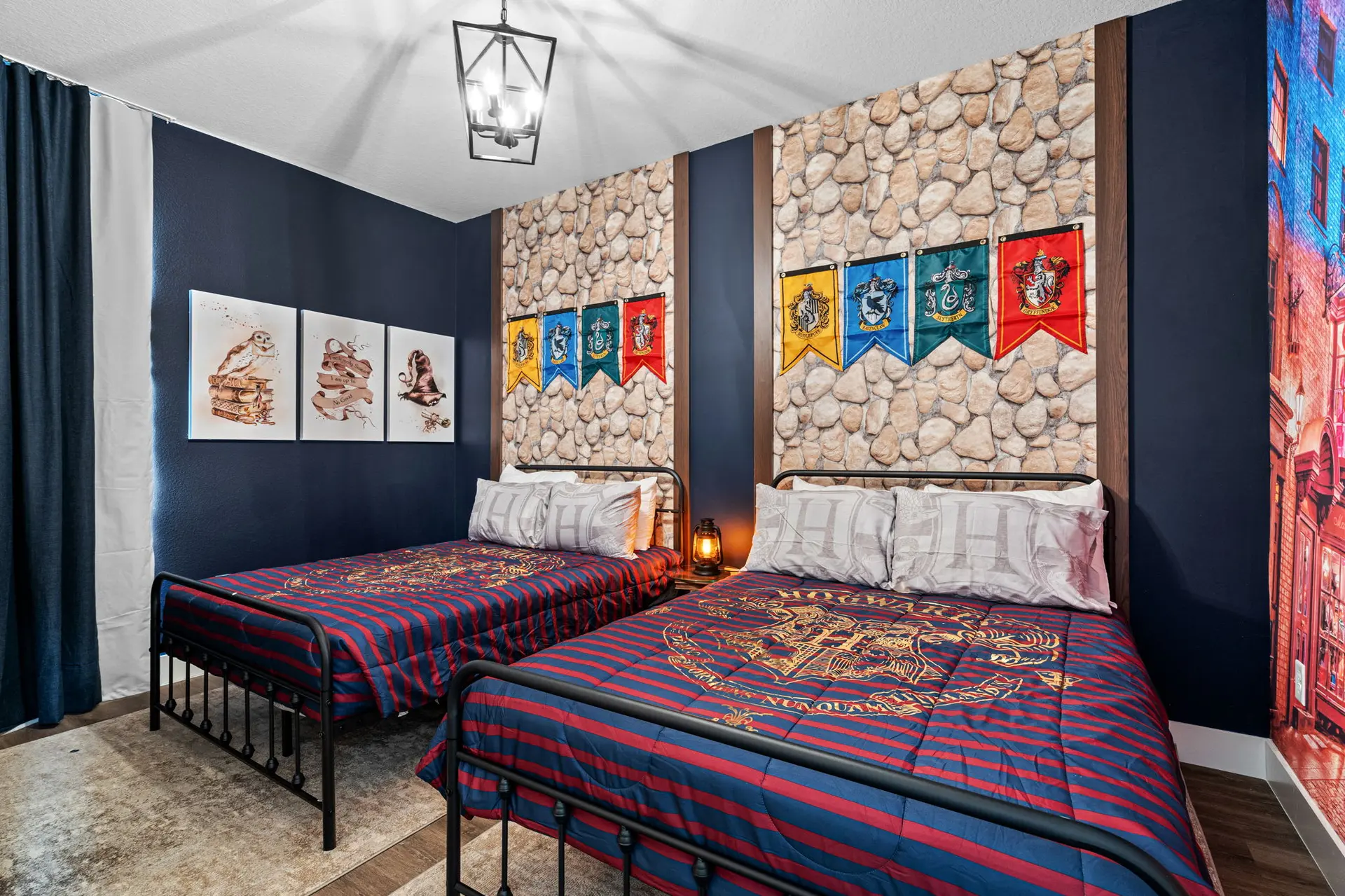 Bedroom with two beds, Harry Potter decor, and stone accent wall.
