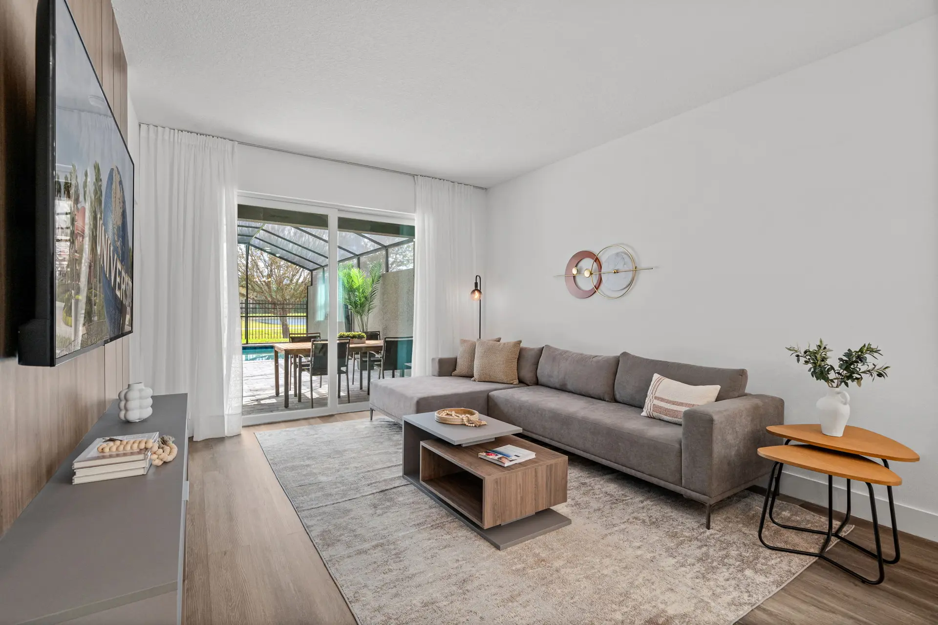 A modern living room with a gray sectional sofa and coffee table in front of a sliding glass door.
