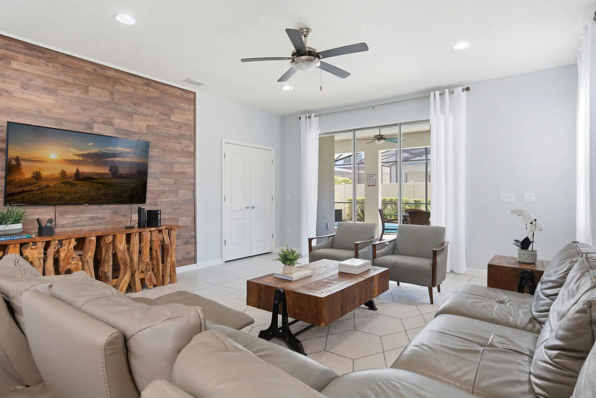 Living room with plush sofas, rustic wood accents, and a large TV.