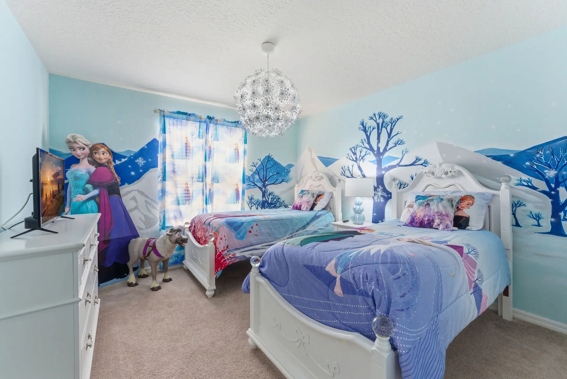 A bedroom with twin beds, Frozen-themed decor, and a TV.
