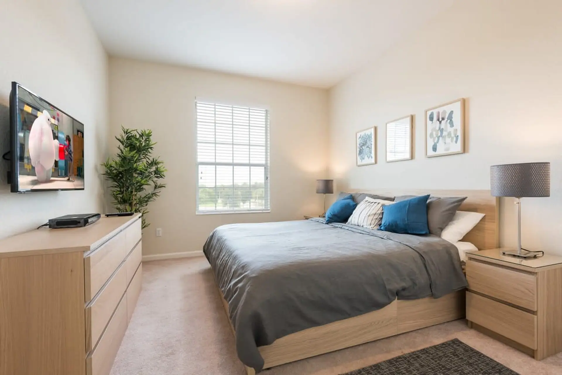 A modern bedroom with a king-size bed and mounted TV.