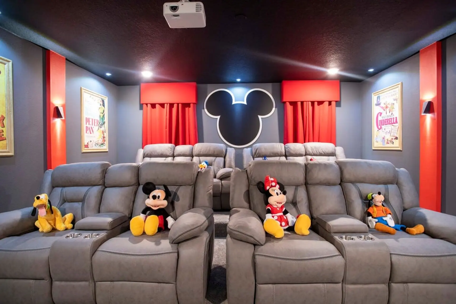 Home theater with gray recliners and Disney characters.