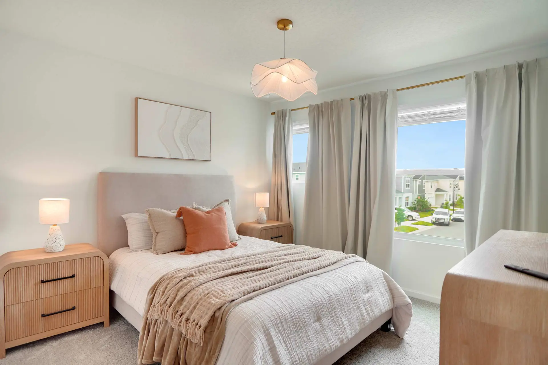 A bedroom with a bed, two nightstands, and artwork above the bed.