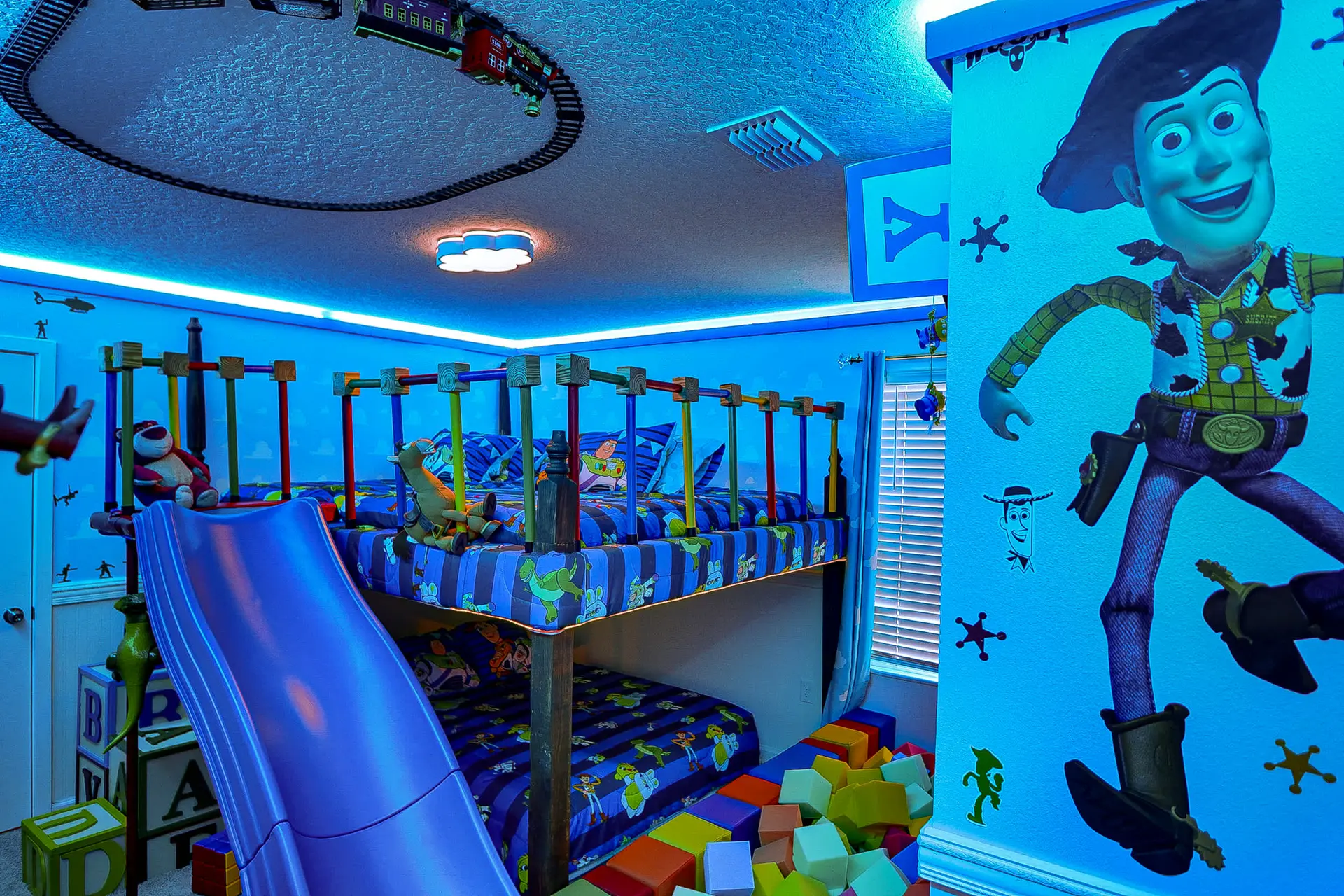 A bedroom themed around Toy Story with bunk beds and a slide.