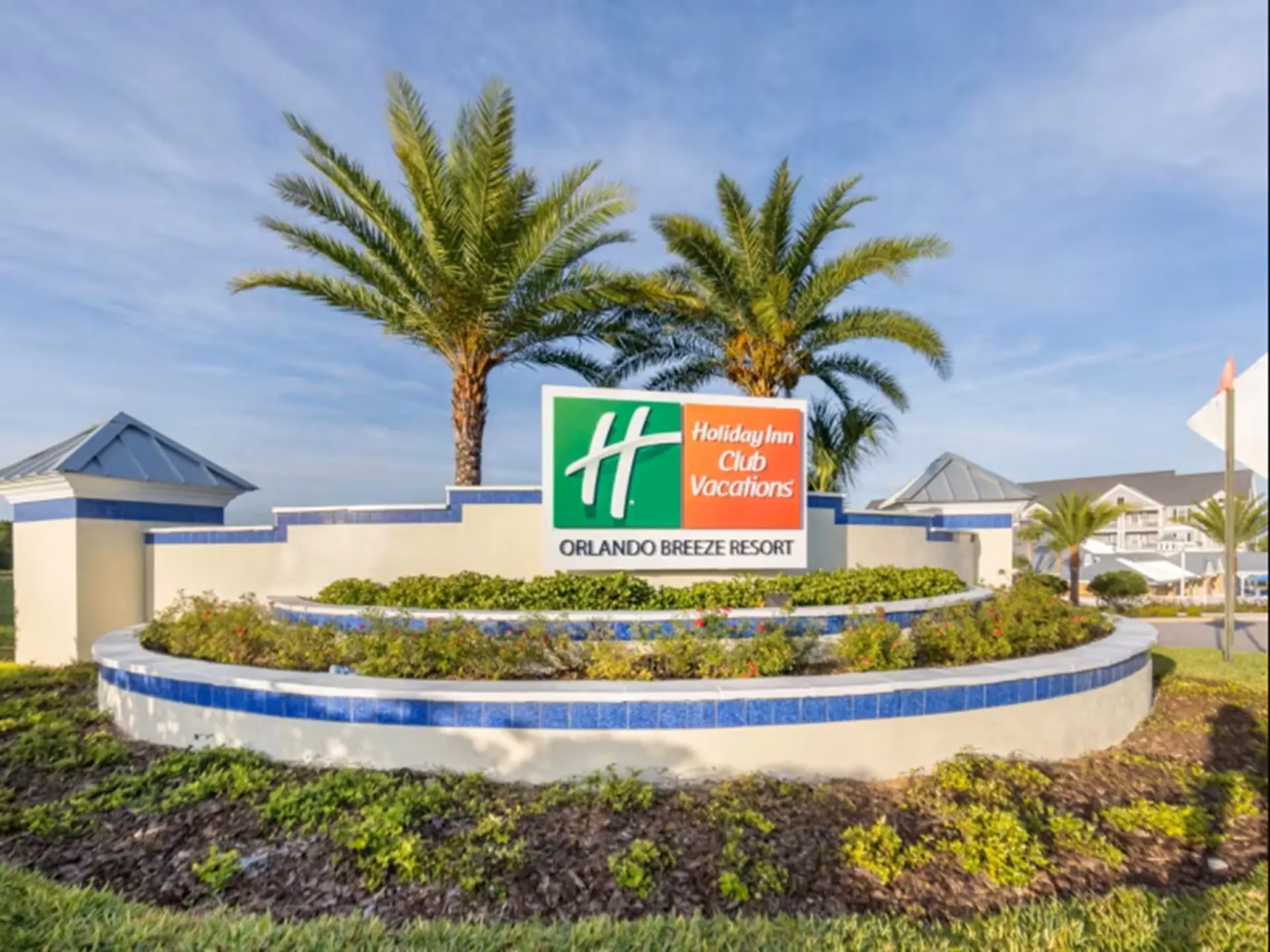 Sign for Holiday Inn Club Vacations Orlando Breeze Resort with palm trees.