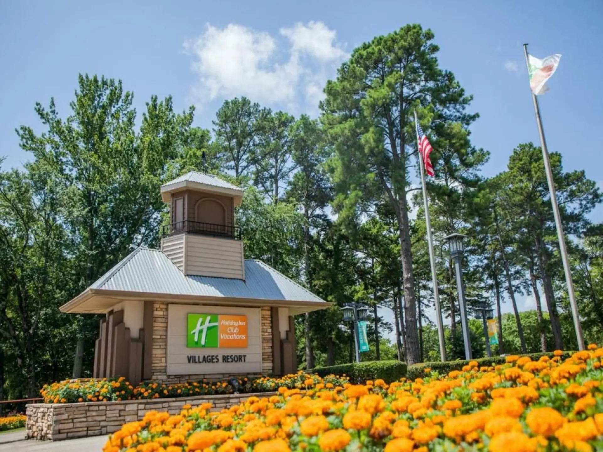 Holiday Inn Club Vacations Villages Resort entrance with orange flowers.