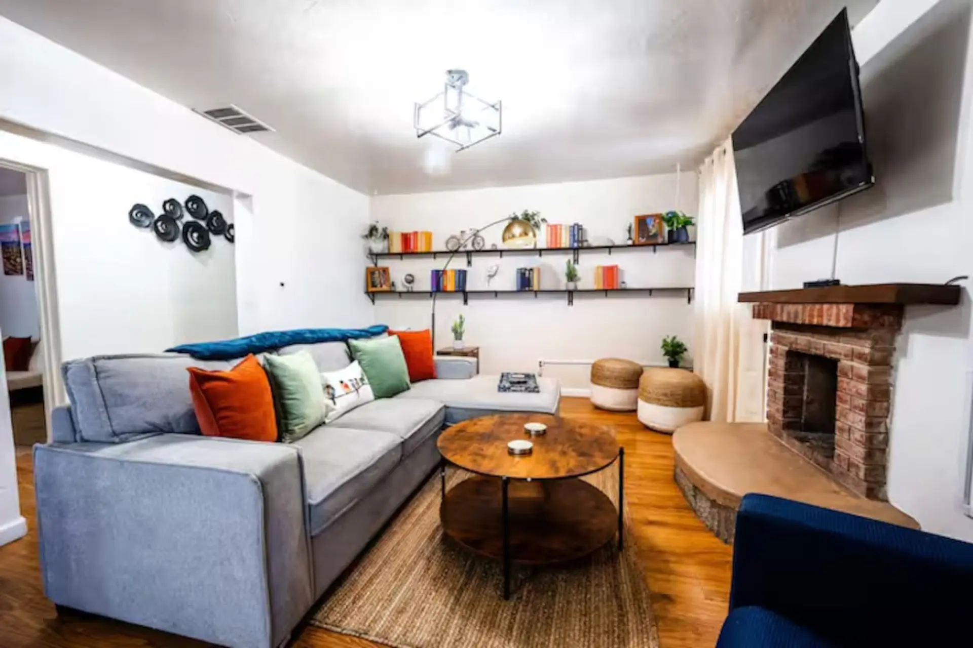 Living room with a gray sectional couch, a coffee table, and a brick fireplace.