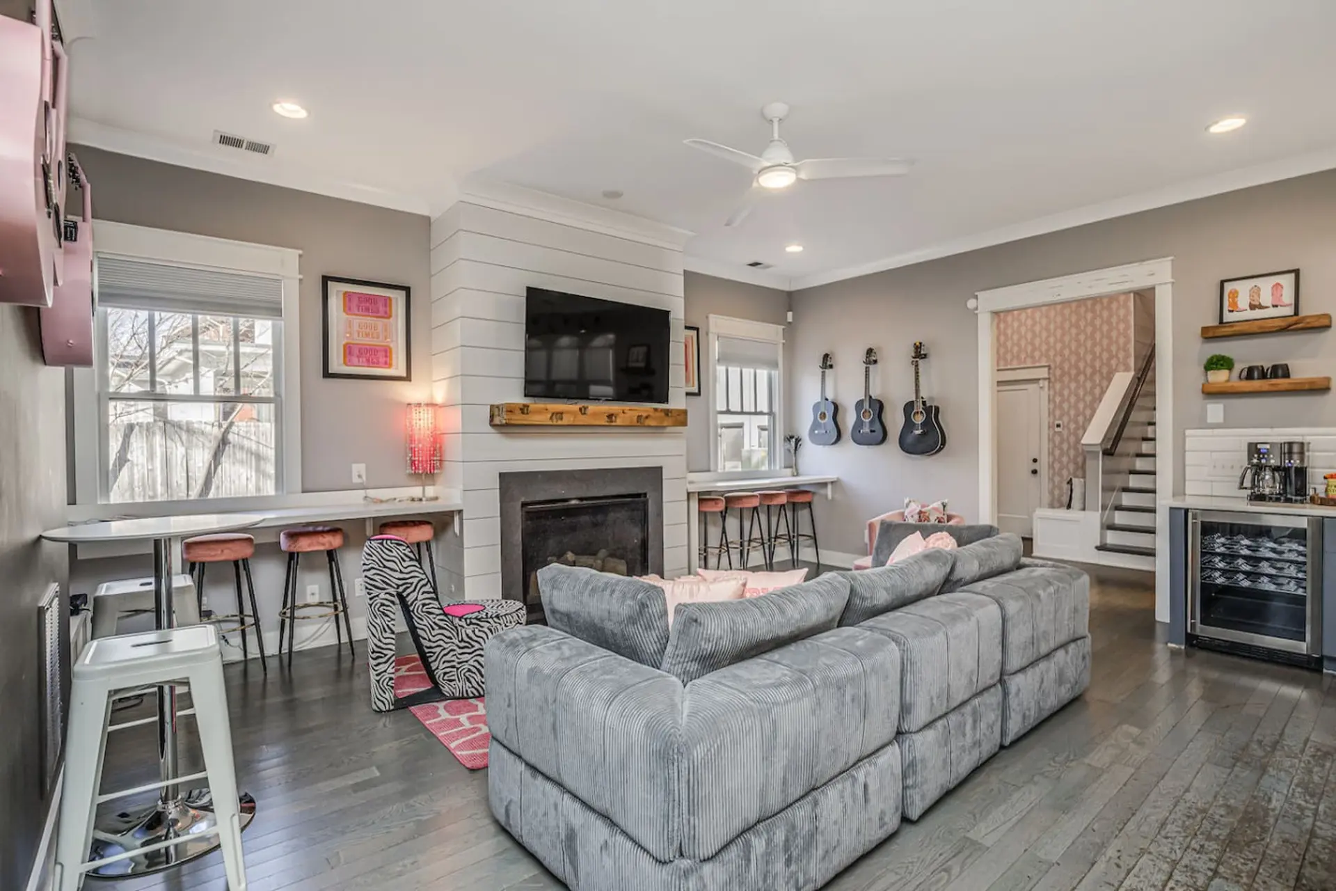 A gray sectional sofa faces a TV mounted above a fireplace.