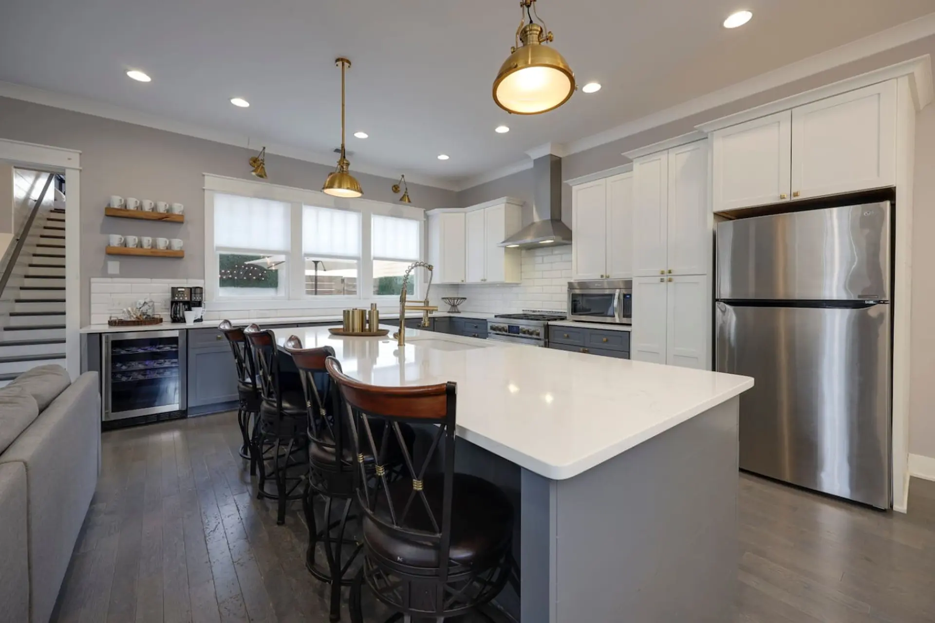 A modern kitchen with a white island and stainless steel appliances.