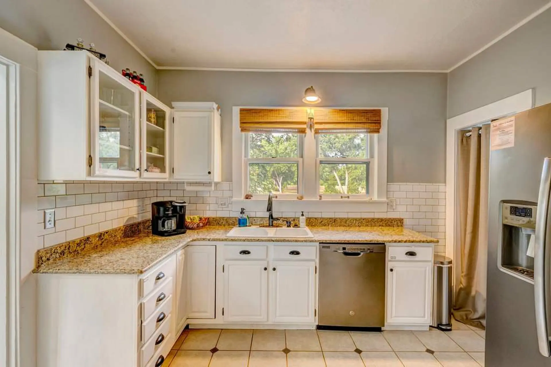 A clean, modern kitchen with white cabinets and granite countertops.