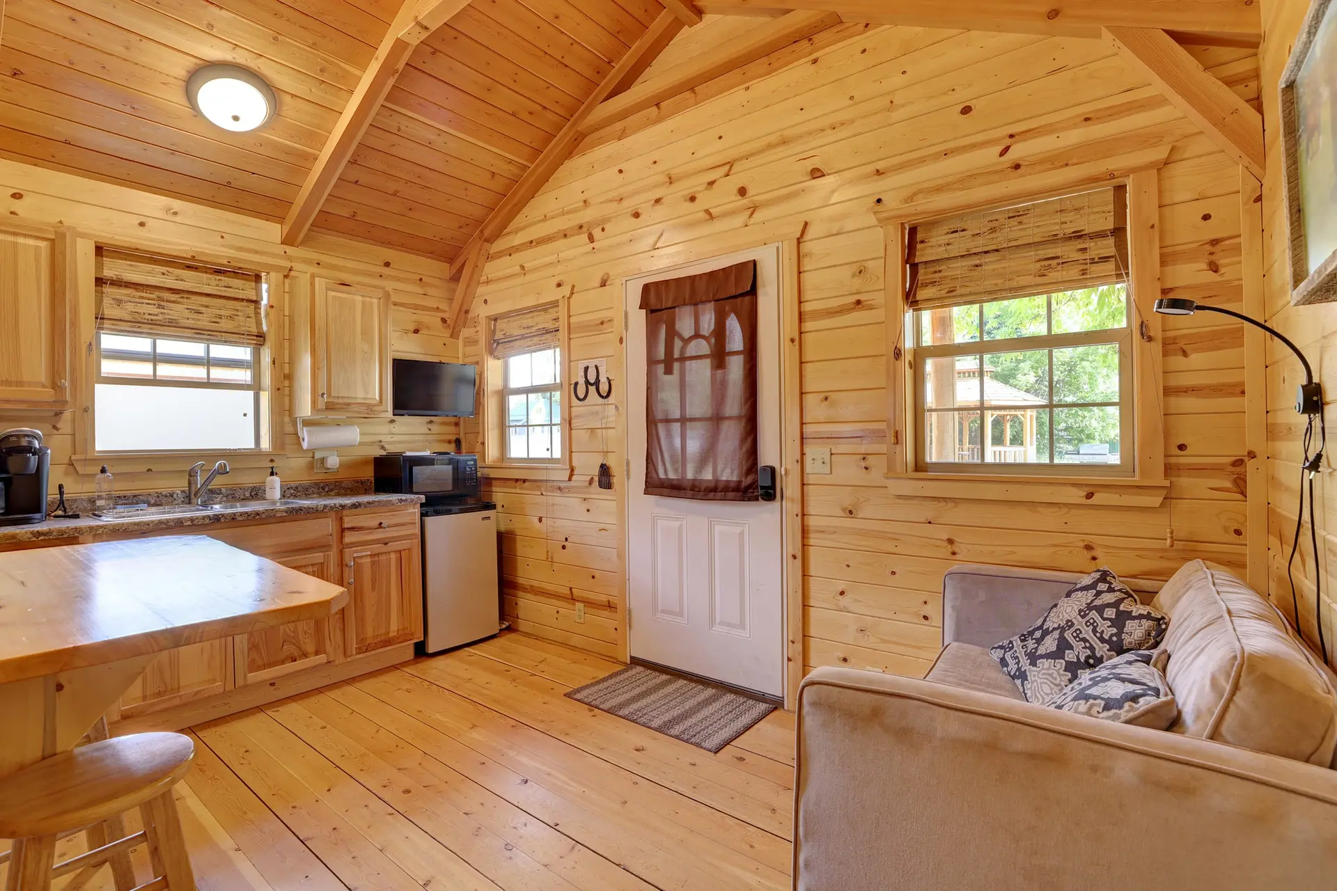 Cozy wooden cabin interior with a kitchenette and seating area.