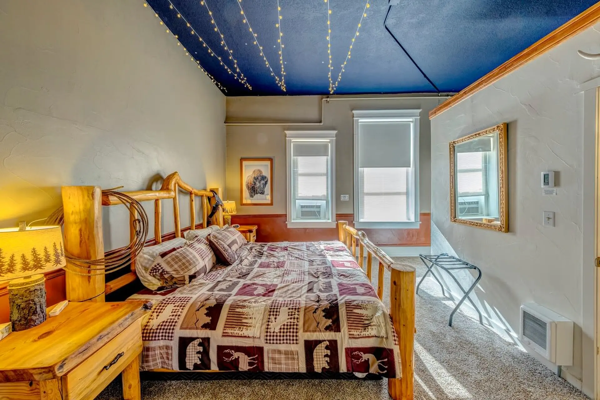 A cozy bedroom with a rustic wooden bed and a western-themed quilt.