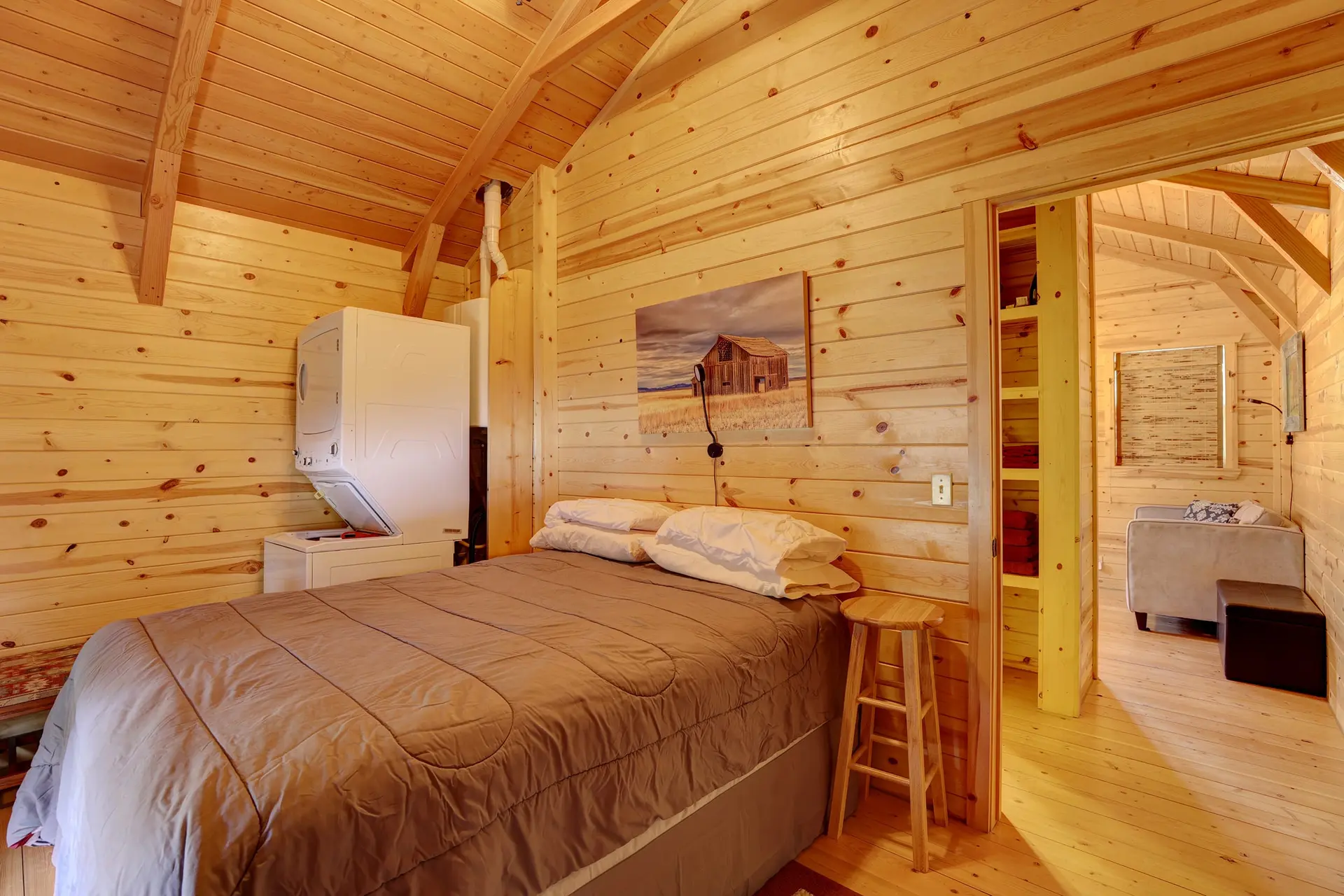 A cozy bedroom with a wood-paneled interior and a bed.