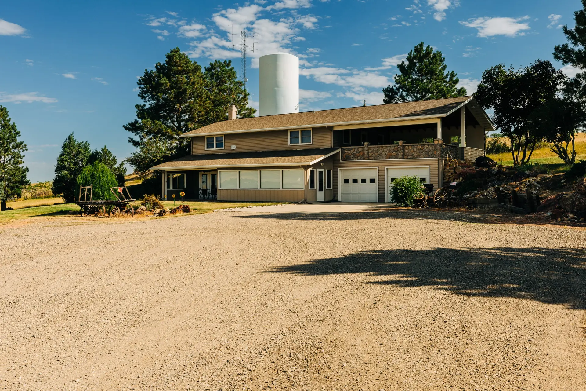 A brown two-story house with a covered porch and attached garage.