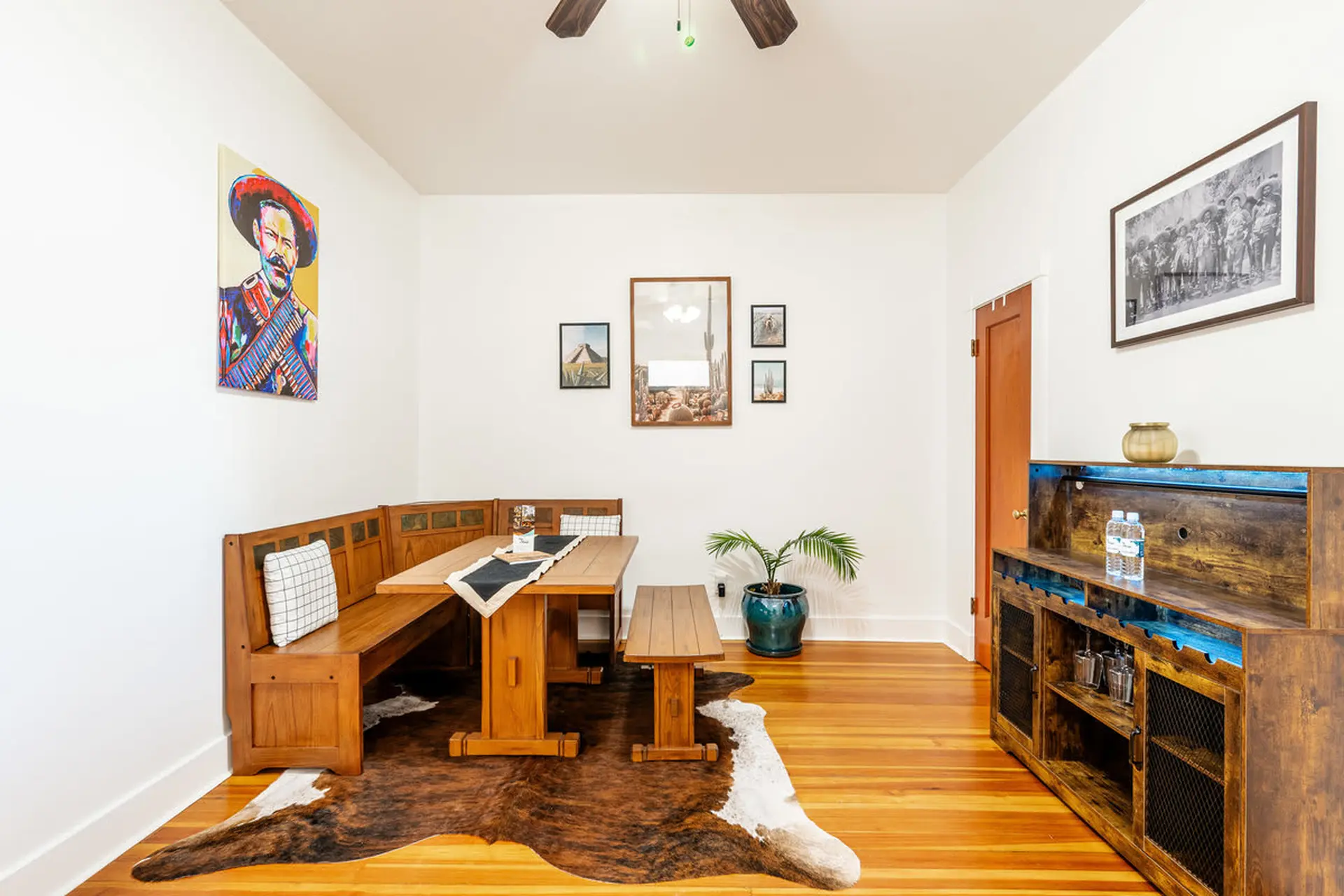 A dining room with a Southwestern theme, featuring a banquette, table, and cowhide rug.