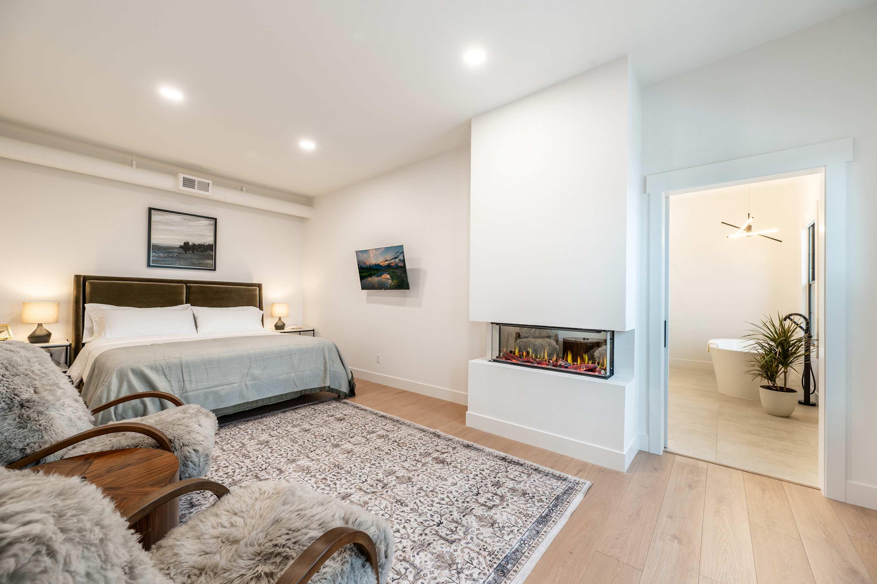 King bedroom with linear fireplace and ensuite bath at The Onyx, The Main Exchange, downtown Sheridan.