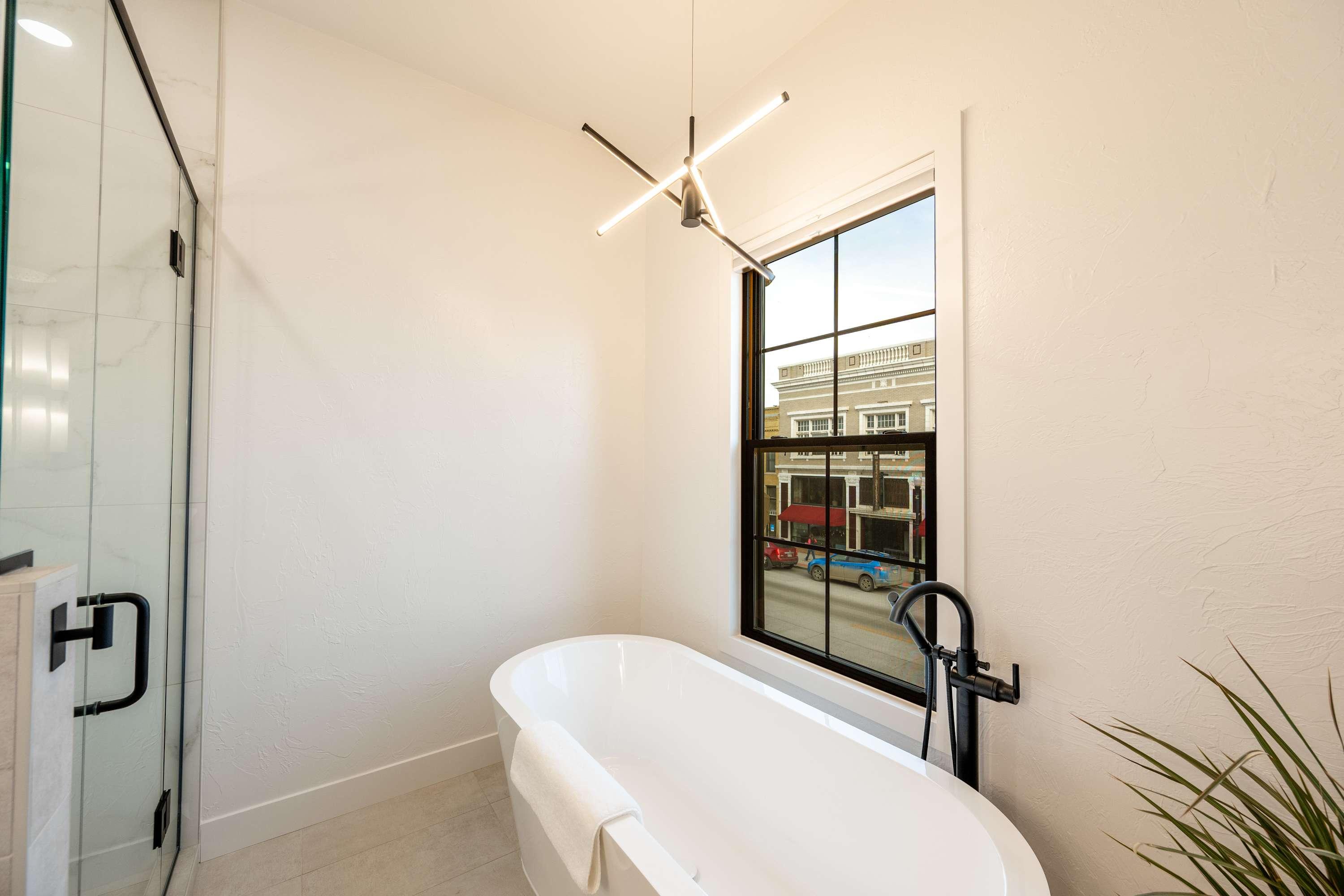 Spa bathroom with freestanding soaking tub overlooking Main Street